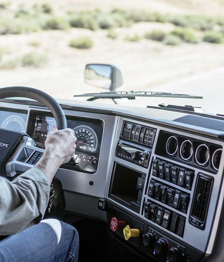 Une personne au volant d'une voiture Description générée automatiquement avec un niveau de confiance moyen