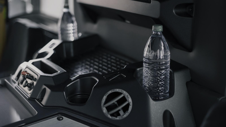 Close-up of expanded storage space in a Mack LR Series truck cab with cup holders