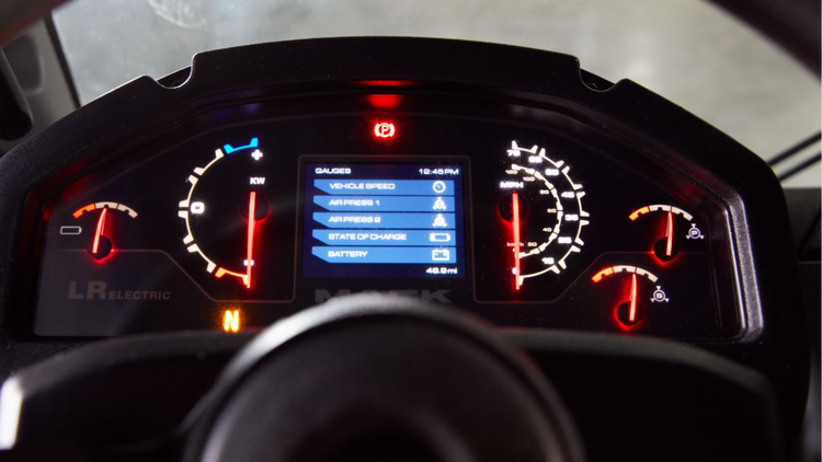 Digital dashboard display in a Mack LR Electric truck, showing vehicle speed, battery status, air pressure, and other key metrics