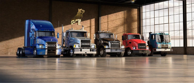 Multiple Mack trucks parked in an outlet.