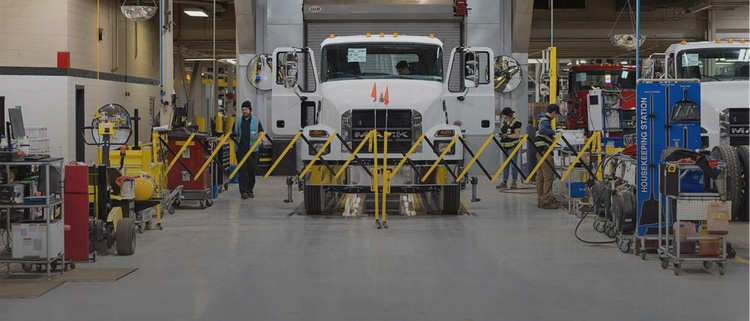A while Mack MD truck in service station.