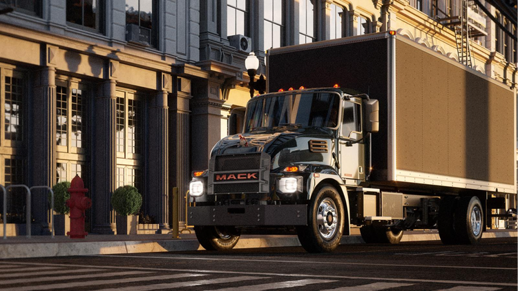 Mack MD electric truck driving down a city street.