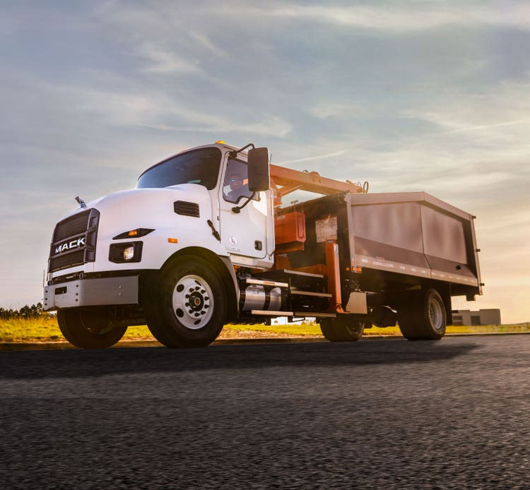 White Mack truck with rear leaf spring suspension, designed for handling heavy loads effortlessly.