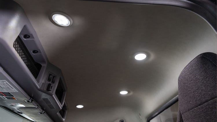 Interior ceiling of the Mack MD Series cab with built-in LED lights and overhead console.